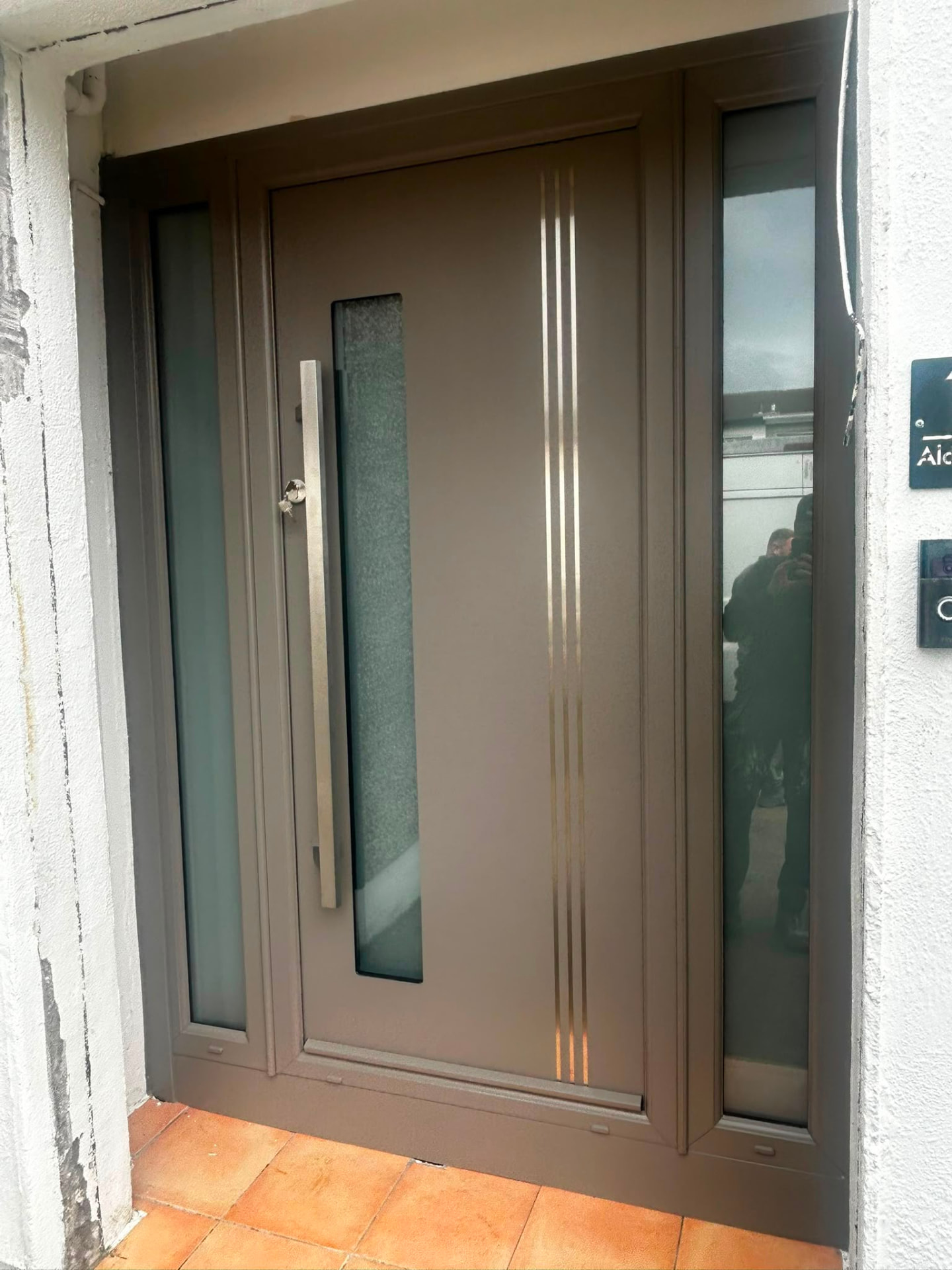 Bronze grey aluminium front door with frosted sidelights and long bar handle