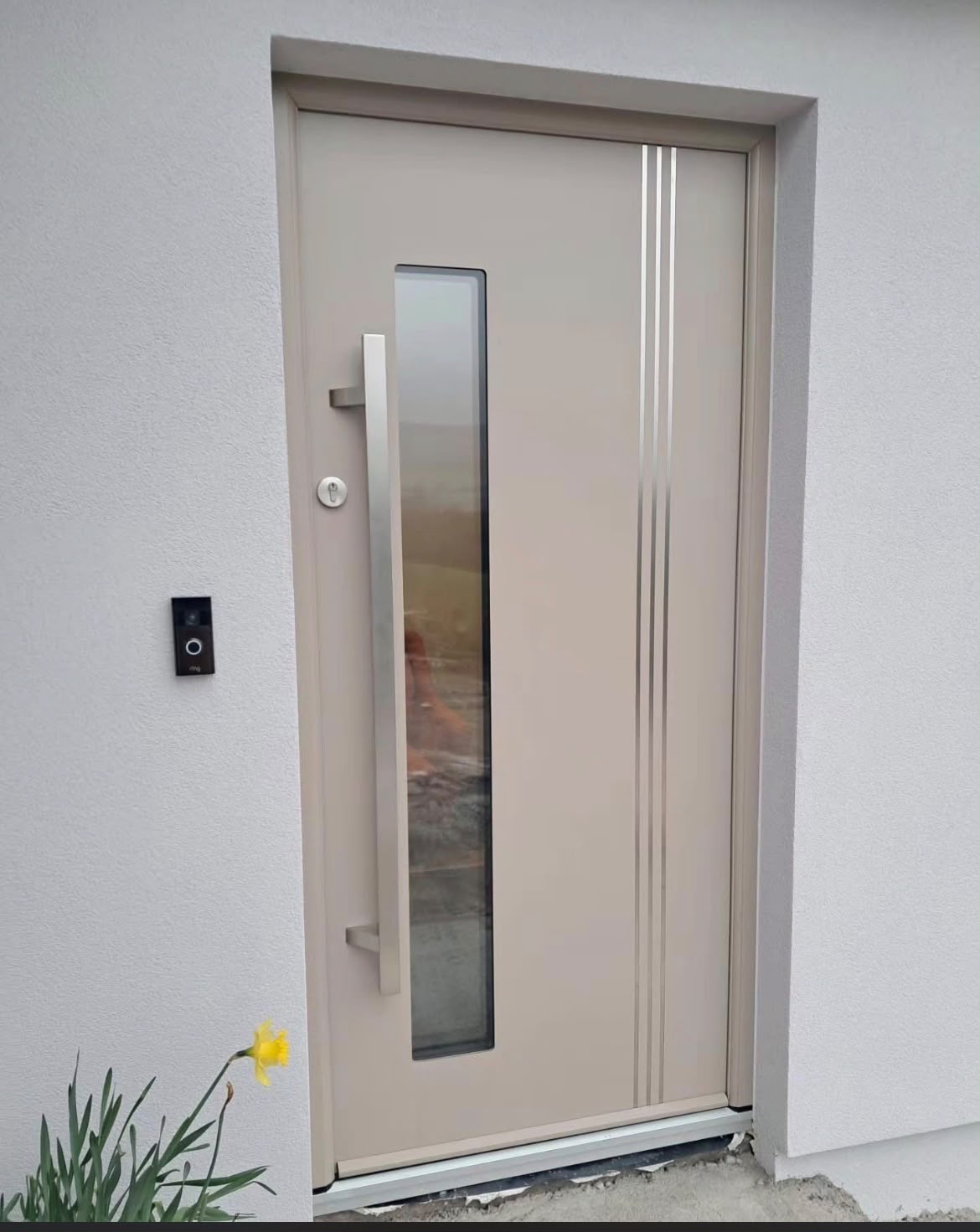 Cream contemporary front door with stainless steel inlays and vertical glass panel
