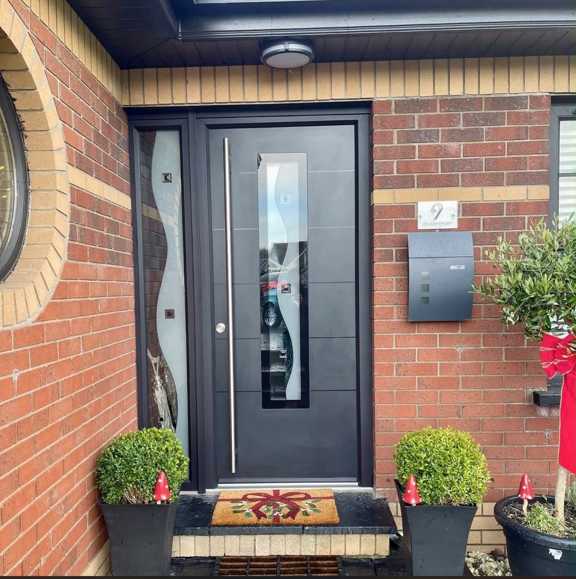 Modern anthracite front door with wave patterned glass and sidelight