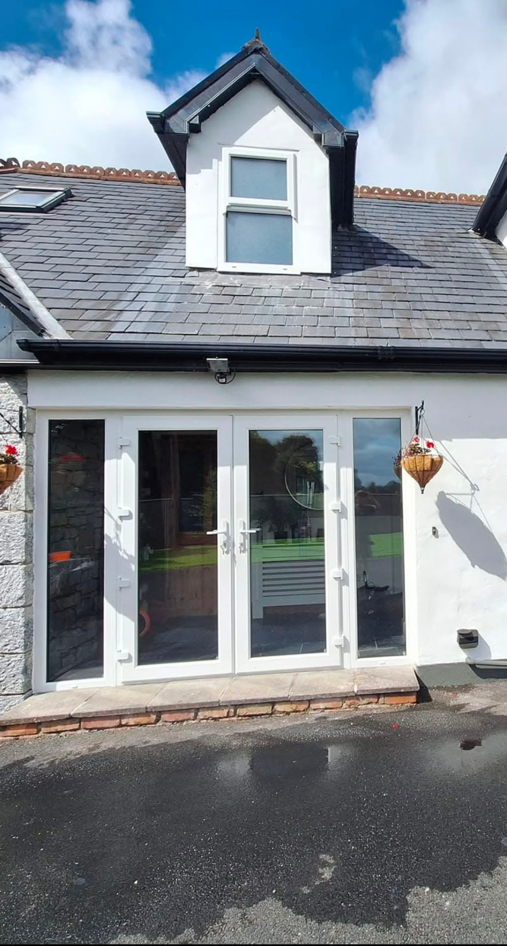 White PVC French doors with full length side panels on a cottage style home