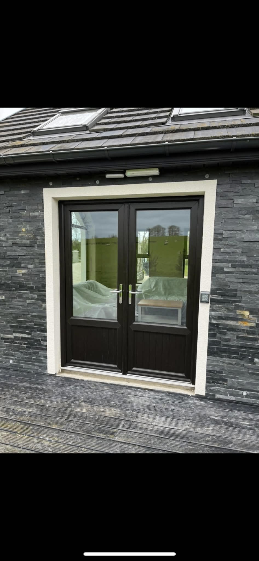 Dark PVC French doors with stone cladding