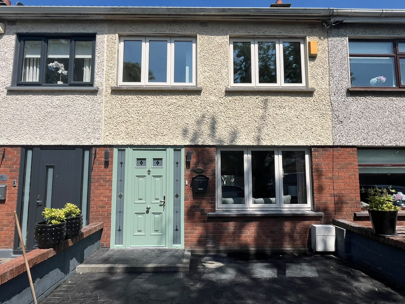 White uPVC casement windows and green composite door on a Dublin terraced house
